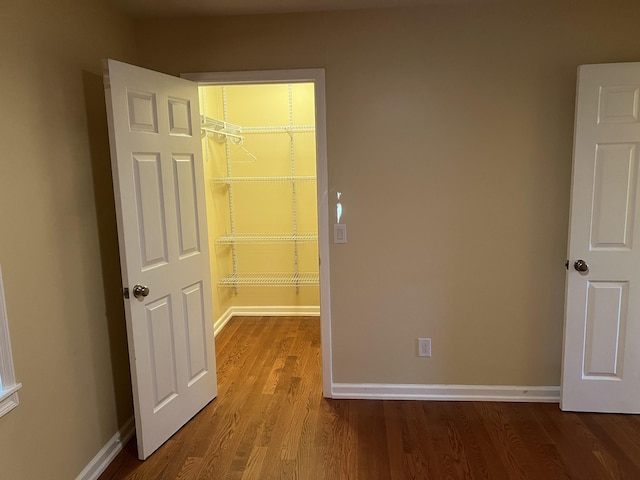 unfurnished room with baseboards and wood finished floors