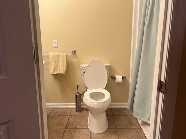 full bath with tile patterned flooring, toilet, and baseboards