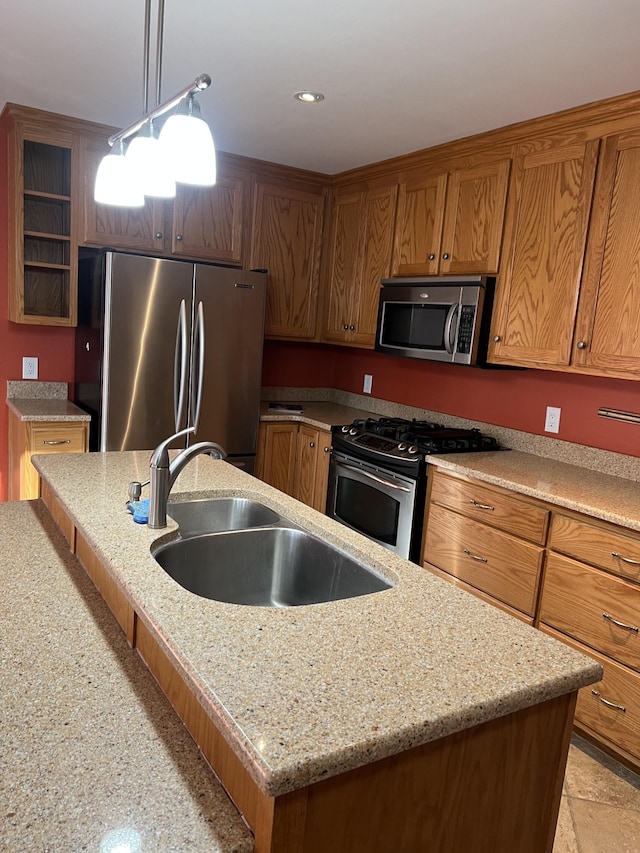 kitchen with stainless steel appliances, a kitchen island, a sink, brown cabinetry, and pendant lighting