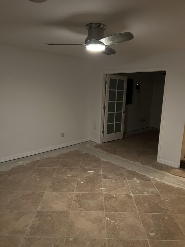 spare room featuring ceiling fan and baseboards