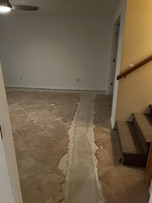 spare room featuring stairs, ceiling fan, and baseboards