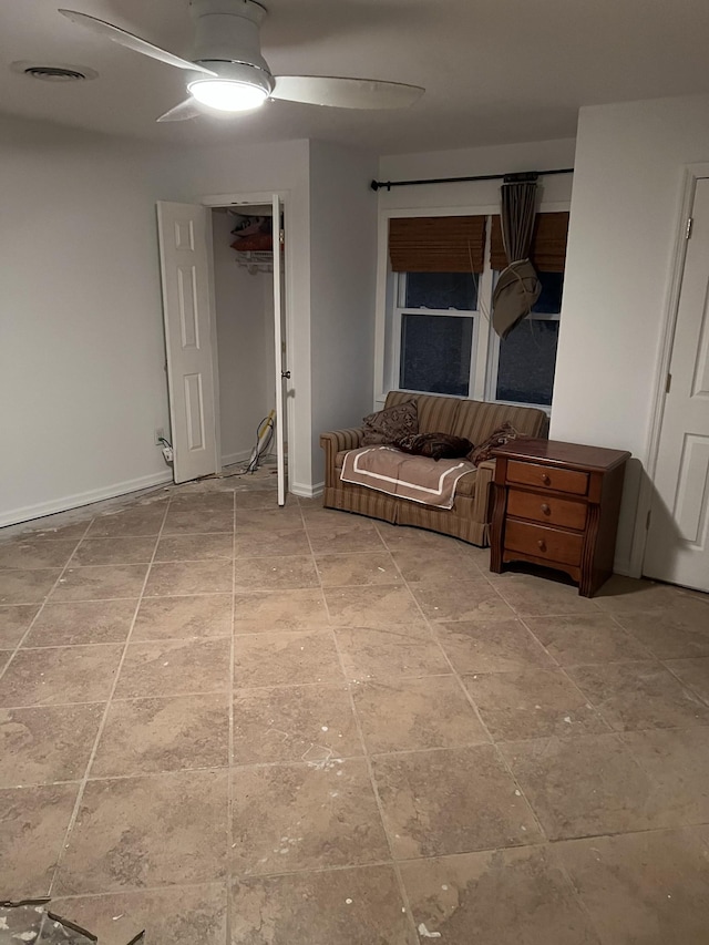 interior space with ceiling fan, visible vents, and baseboards