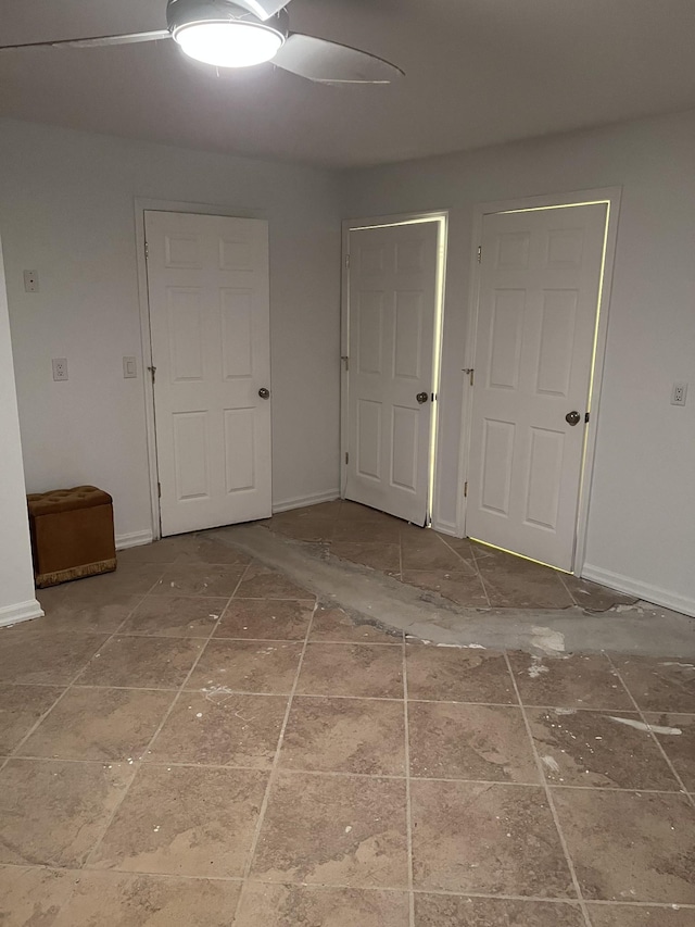 unfurnished room with a ceiling fan and baseboards