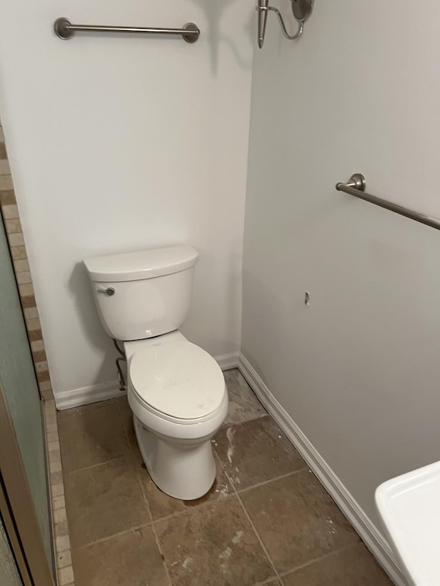 bathroom with baseboards and toilet