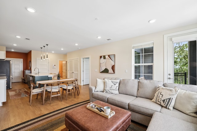 living room with sink and light hardwood / wood-style floors