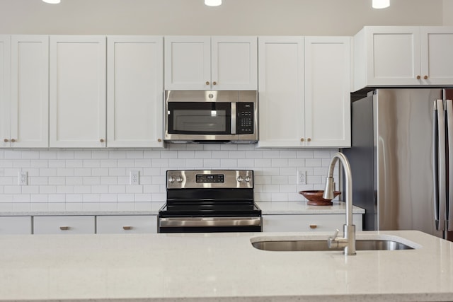 kitchen featuring light stone counters, white cabinets, and appliances with stainless steel finishes