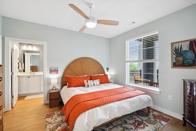 bedroom featuring ceiling fan, light hardwood / wood-style flooring, and connected bathroom