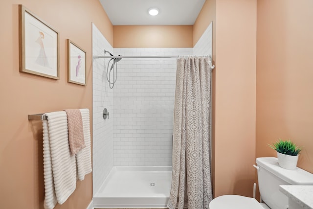 bathroom with walk in shower, vanity, and toilet