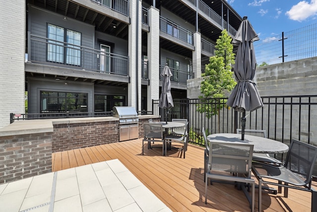 wooden deck featuring area for grilling and a grill