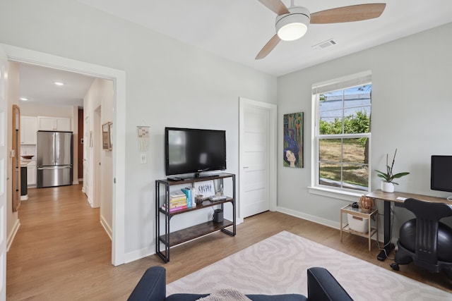 living room featuring ceiling fan and light hardwood / wood-style flooring