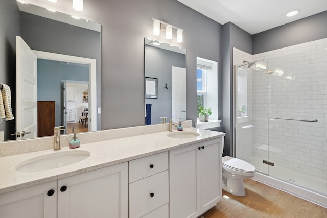 bathroom featuring vanity, toilet, an enclosed shower, and hardwood / wood-style flooring