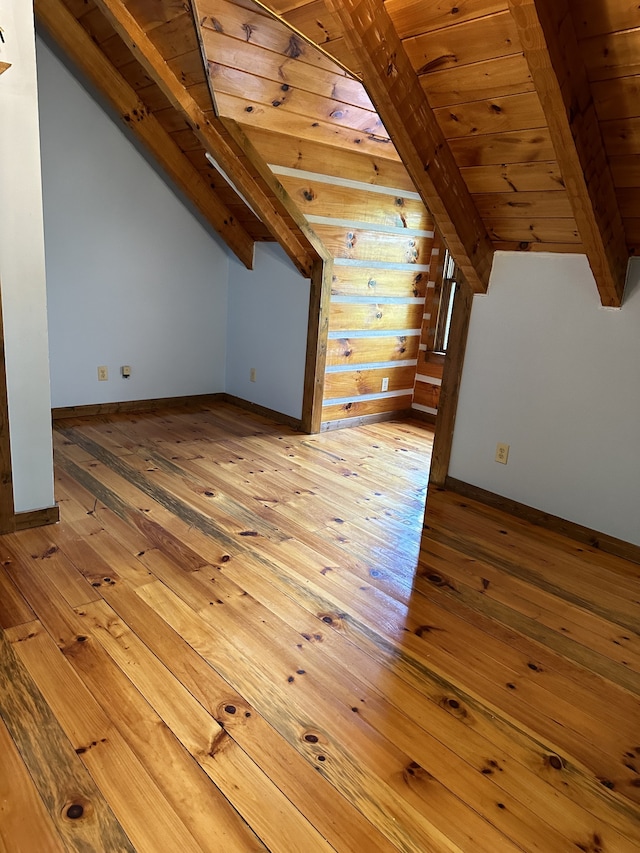 bonus room featuring light wood-type flooring, lofted ceiling with beams, and wooden ceiling