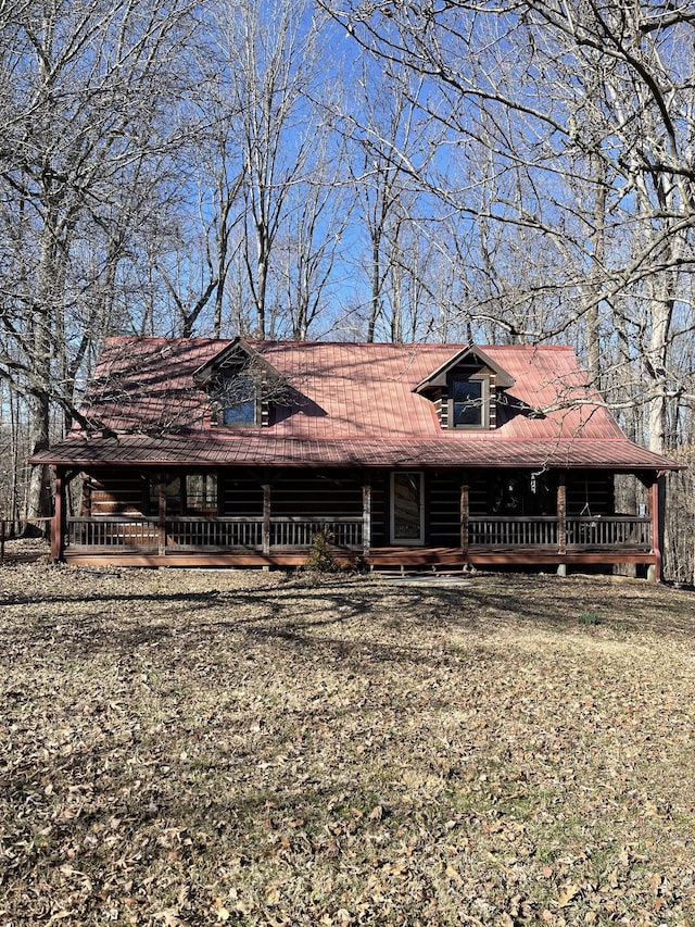 view of front of property with metal roof, a front lawn, and log siding