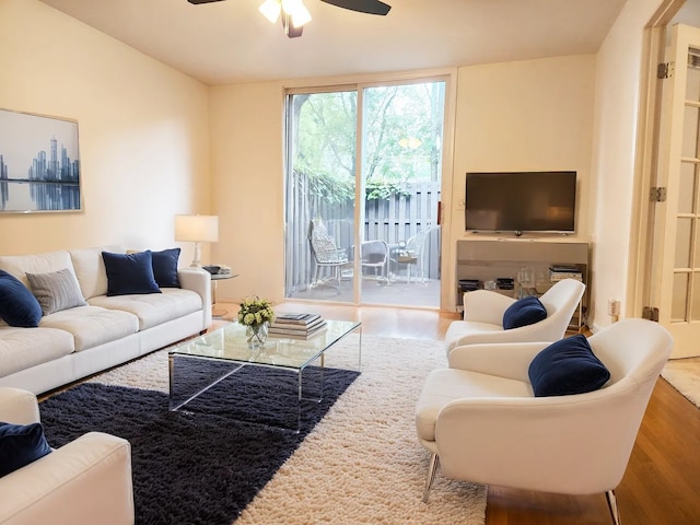 living room featuring ceiling fan and hardwood / wood-style flooring