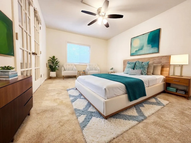 bedroom featuring ceiling fan, light colored carpet, and french doors