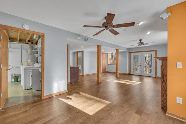 empty room featuring light wood-type flooring, ceiling fan, french doors, gas water heater, and washing machine and dryer