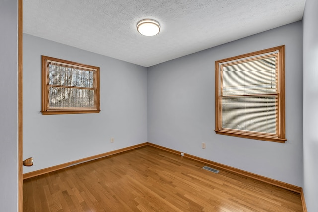 empty room featuring light hardwood / wood-style floors and a textured ceiling