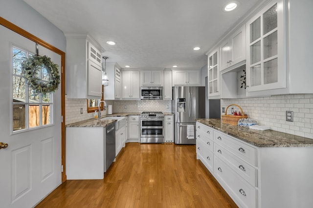 kitchen featuring hanging light fixtures, appliances with stainless steel finishes, and white cabinetry