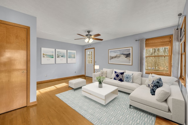 living room with ceiling fan, hardwood / wood-style floors, and a textured ceiling