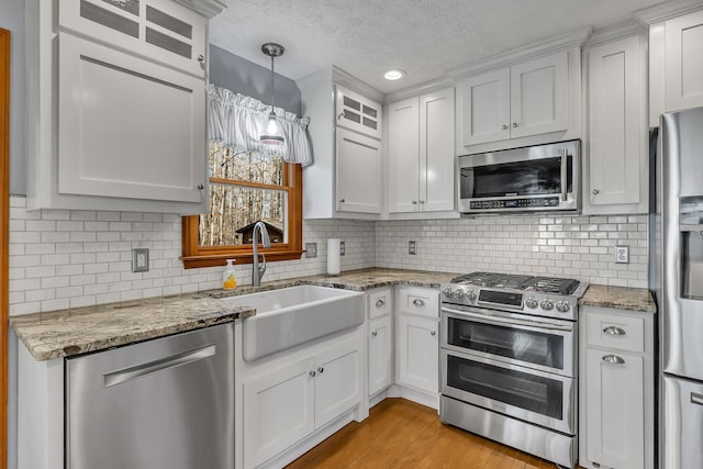 kitchen featuring white cabinets, stainless steel appliances, backsplash, and sink