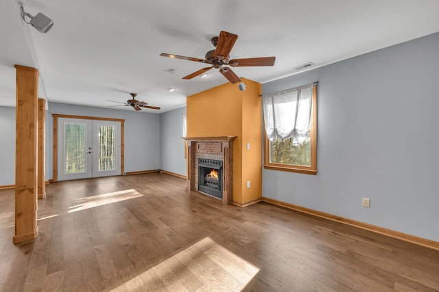 unfurnished living room with ceiling fan, french doors, and light hardwood / wood-style floors