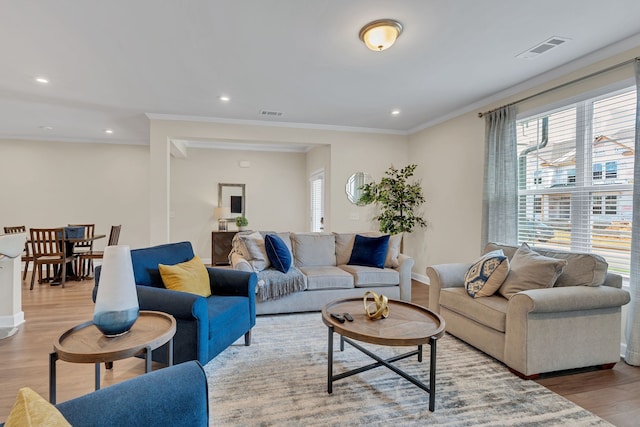 living room with light hardwood / wood-style floors and crown molding