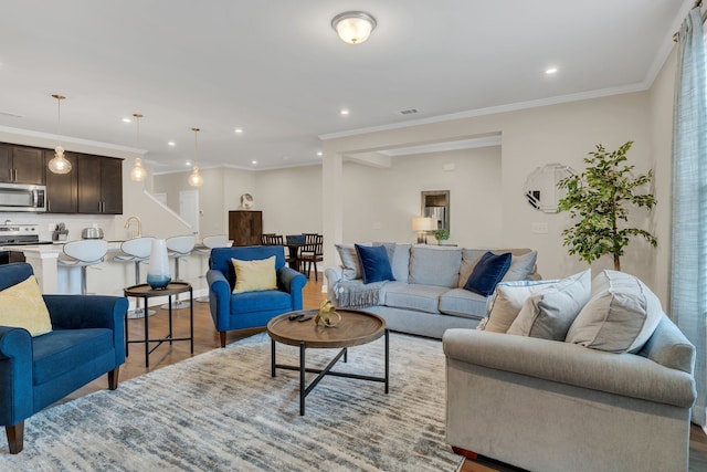 living room with ornamental molding, light hardwood / wood-style floors, and sink