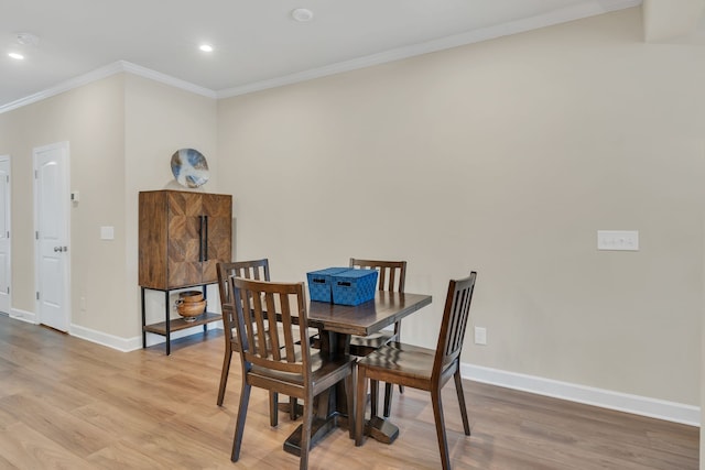 dining space featuring light hardwood / wood-style flooring and ornamental molding