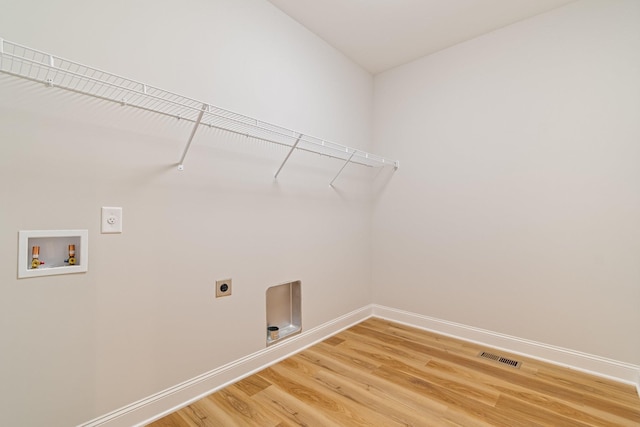 laundry area with hookup for an electric dryer, laundry area, visible vents, light wood-style flooring, and baseboards