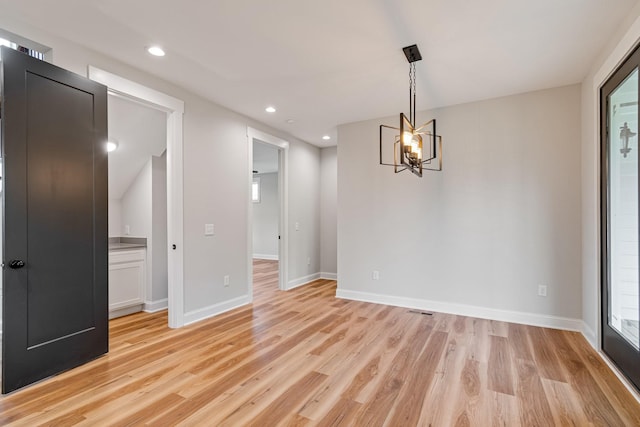 empty room featuring an inviting chandelier, light wood-style floors, recessed lighting, and baseboards