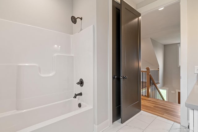 bathroom featuring bathtub / shower combination and marble finish floor