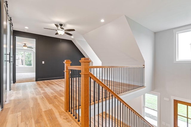 hall featuring light wood-type flooring, recessed lighting, an upstairs landing, and plenty of natural light