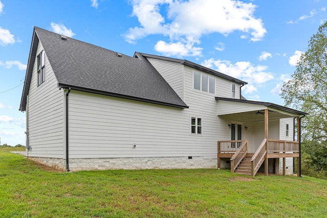 rear view of property featuring a lawn, stairway, ceiling fan, and a shingled roof