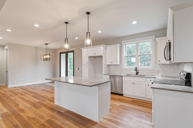 kitchen with a sink, appliances with stainless steel finishes, a wealth of natural light, and tasteful backsplash