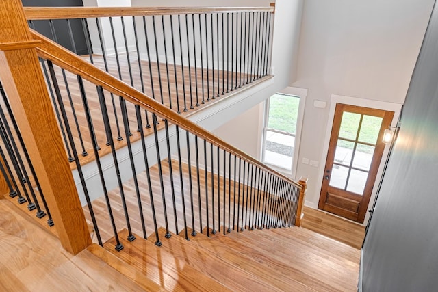 stairs with a towering ceiling and wood finished floors