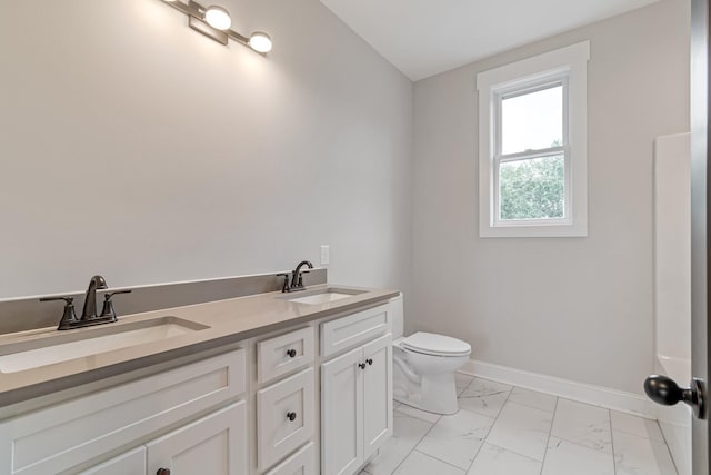 bathroom with toilet, baseboards, marble finish floor, and a sink