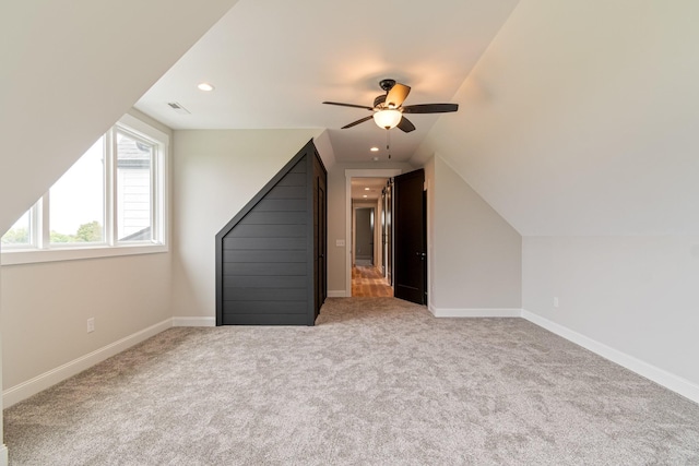 additional living space with ceiling fan, carpet flooring, baseboards, visible vents, and lofted ceiling