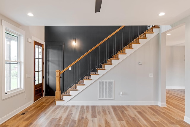 interior space with baseboards, visible vents, wood finished floors, and stairway
