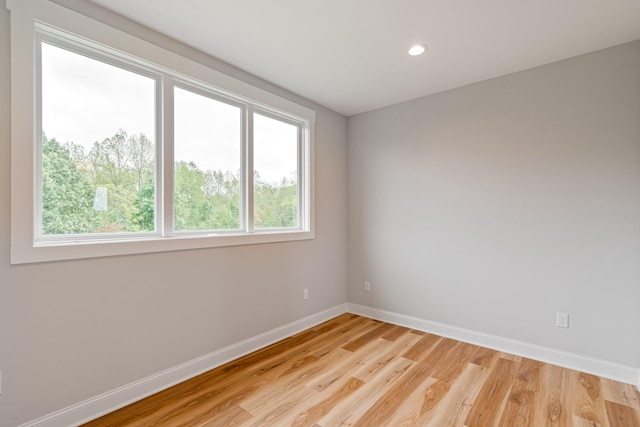 spare room with baseboards, light wood-type flooring, and recessed lighting