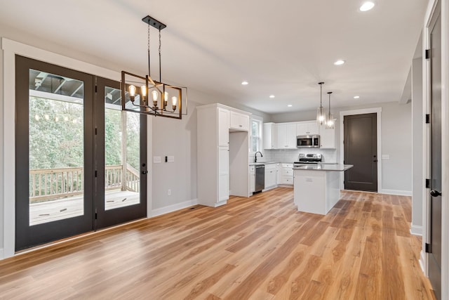 kitchen featuring a chandelier, appliances with stainless steel finishes, light countertops, white cabinets, and baseboards
