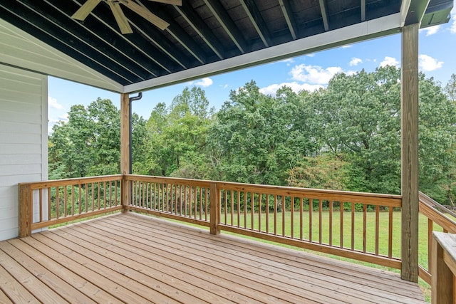 wooden terrace featuring ceiling fan and a yard