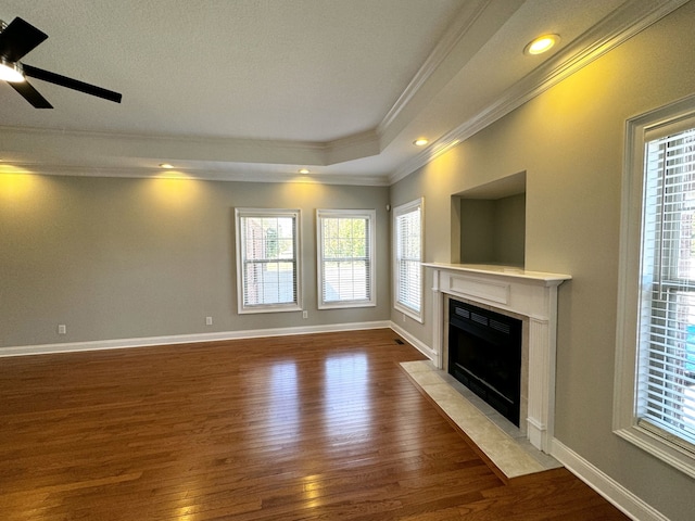 unfurnished living room with ornamental molding, a tiled fireplace, light wood-type flooring, and ceiling fan