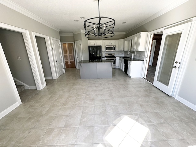 kitchen featuring white cabinets, a chandelier, black appliances, pendant lighting, and a center island