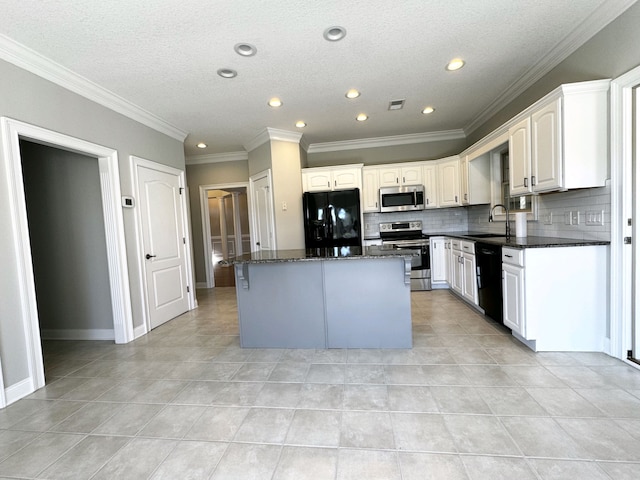 kitchen featuring white cabinetry, a center island, black appliances, and ornamental molding