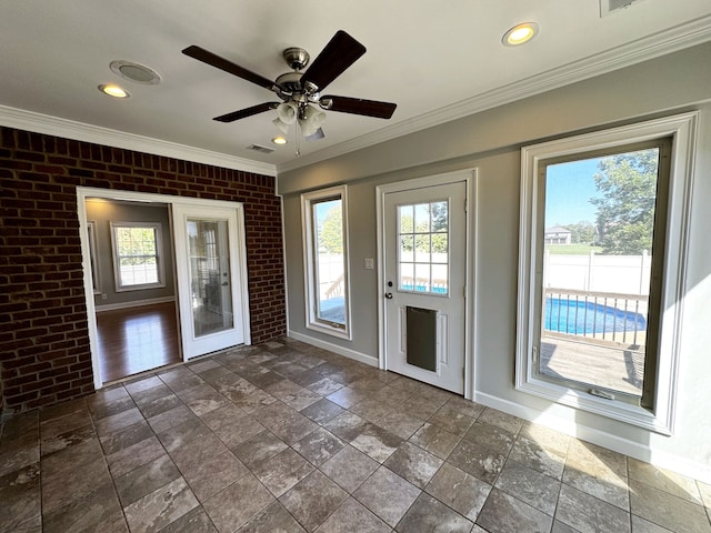 interior space featuring ornamental molding, brick wall, and ceiling fan