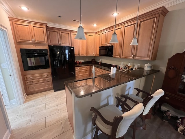 kitchen featuring dark stone countertops, kitchen peninsula, black appliances, decorative light fixtures, and ornamental molding