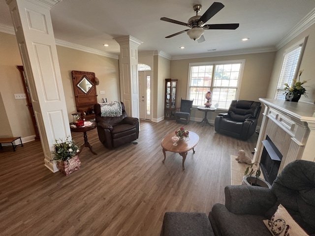 living room with ceiling fan, ornamental molding, wood-type flooring, and a tile fireplace