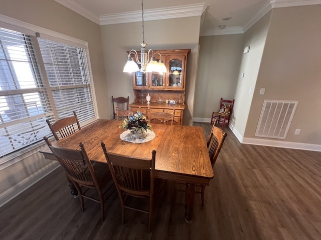 dining space with ornamental molding, a chandelier, and dark hardwood / wood-style floors