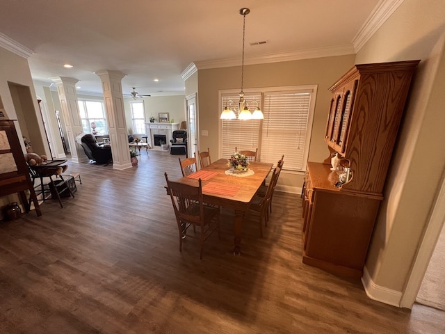 dining room featuring ceiling fan with notable chandelier, crown molding, dark hardwood / wood-style floors, and ornate columns