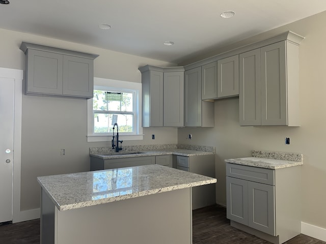 kitchen with gray cabinetry, a center island, dark wood-type flooring, and sink